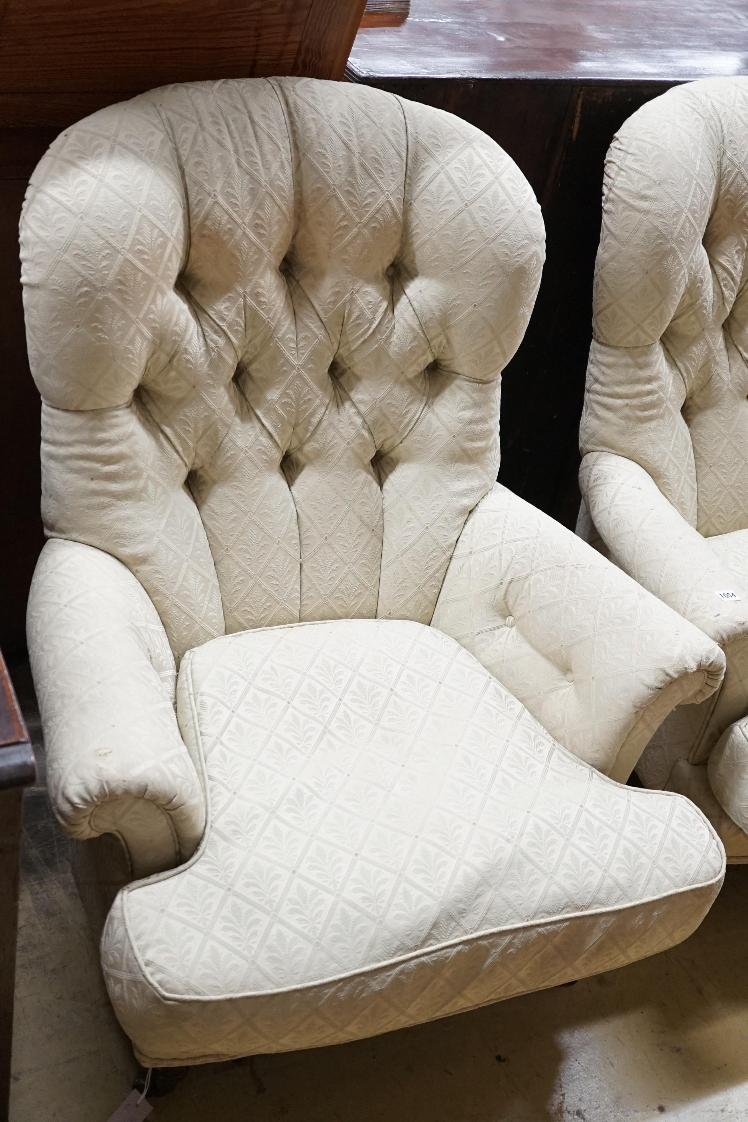 A pair of Liberty of London Victorian style button back armchairs with mahogany legs and brass castors, width 83cm, height 100cm